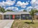 Charming single-story home with a well-manicured lawn and a vibrant, welcoming orange front door at 8497 Portulaca Ave, Seminole, FL 33777