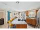 Kitchen with a large island, oak cabinets, stylish backsplash, and easy access to the backyard and adjacent rooms at 8497 Portulaca Ave, Seminole, FL 33777