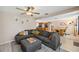 Open-concept living room with a large sectional sofa flowing into a dining area and modern kitchen at 8497 Portulaca Ave, Seminole, FL 33777