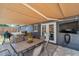 A covered outdoor dining area featuring a built-in grill and exterior mounted television at 8497 Portulaca Ave, Seminole, FL 33777