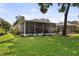 Backyard showing an expansive lawn, screened patio, and space for outdoor relaxation at 8562 Acorn Ridge Ct, Tampa, FL 33625