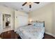 Cozy bedroom with ceiling fan, closet, dark floors, and light yellow walls for a bright space at 8562 Acorn Ridge Ct, Tampa, FL 33625