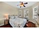 A tranquil bedroom with a ceiling fan and shuttered windows at 8562 Acorn Ridge Ct, Tampa, FL 33625