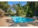 Bright community pool with lounge chairs and blue umbrellas surrounded by mature trees at 8562 Acorn Ridge Ct, Tampa, FL 33625