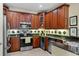 Well-appointed kitchen features cherry cabinets, granite countertops, and modern stainless steel appliances at 8562 Acorn Ridge Ct, Tampa, FL 33625