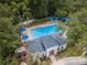 Aerial view of a community pool with blue umbrellas, lounge chairs, and lush landscaping at 8562 Acorn Ridge Ct, Tampa, FL 33625