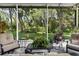 Comfortable screened-in porch featuring cushioned chairs and a view of the lush backyard at 8562 Acorn Ridge Ct, Tampa, FL 33625
