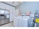 Practical laundry area with updated appliances, storage cabinets and adjacent stainless steel fridge at 902 W Columbus Dr, Tampa, FL 33602