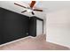 Bedroom with tan carpet, black accent wall, white ceiling and a ceiling fan at 937 Royal Empress Dr, Ruskin, FL 33570