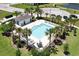 Community pool area with palm trees, lounge chairs and poolside clubhouse at 937 Royal Empress Dr, Ruskin, FL 33570