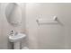Elegant half bath with a pedestal sink, oval mirror, and neutral decor at 937 Royal Empress Dr, Ruskin, FL 33570
