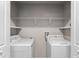 Inside laundry room with a white washer and dryer, white shelves and door at 937 Royal Empress Dr, Ruskin, FL 33570