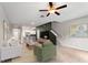 Cozy living room with a ceiling fan, an adjacent kitchen and stairway to the second floor at 937 Royal Empress Dr, Ruskin, FL 33570