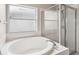 Bathroom features soaking tub, glass door shower, and frosted window at 9479 Southern Charm Cir, Brooksville, FL 34613