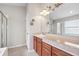Bathroom features double sinks, wood cabinets, and glass door shower at 9479 Southern Charm Cir, Brooksville, FL 34613