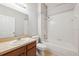 Bathroom featuring a vanity with mirror and shower-tub combo with white tile surround at 9479 Southern Charm Cir, Brooksville, FL 34613
