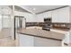 Modern kitchen boasts stainless steel appliances, a stone backsplash, and a large island with a breakfast bar at 9479 Southern Charm Cir, Brooksville, FL 34613