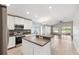 Open kitchen features stainless steel appliances, stone backsplash, and breakfast bar for easy entertaining at 9479 Southern Charm Cir, Brooksville, FL 34613