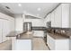 Bright kitchen features stainless steel appliances, unique stone backsplash, and ample counter space at 9479 Southern Charm Cir, Brooksville, FL 34613