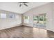 Bright living room with ceiling fan, hardwood floors, and glass sliding door at 9479 Southern Charm Cir, Brooksville, FL 34613