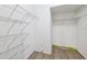 Spacious walk-in closet featuring white walls and metal shelving with wood-look laminate flooring throughout at 9479 Southern Charm Cir, Brooksville, FL 34613