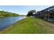 Grassy backyard with waterfront views and screen enclosed pool area at 10522 Sky Flower Ct, Land O Lakes, FL 34638