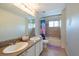 Bright bathroom features double sinks, granite countertop and a shower-tub combination at 10522 Sky Flower Ct, Land O Lakes, FL 34638