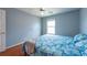 Bedroom with hardwood floors, ceiling fan, light blue walls, and a comfortable bed offers a serene living space at 10522 Sky Flower Ct, Land O Lakes, FL 34638