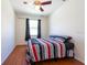 Cozy bedroom with a ceiling fan, warm wood floors, and natural light, perfect for restful nights at 10522 Sky Flower Ct, Land O Lakes, FL 34638