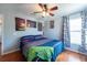 This spacious bedroom has wood floors, ceiling fan, and a window with matching curtains at 10522 Sky Flower Ct, Land O Lakes, FL 34638