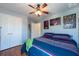 Bedroom features hardwood floor, ceiling fan, blue accent wall and closet with white doors at 10522 Sky Flower Ct, Land O Lakes, FL 34638
