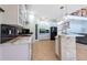 Bright kitchen with white cabinets, black backsplash, tiled island, and stainless steel appliances at 10522 Sky Flower Ct, Land O Lakes, FL 34638