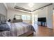 Well-lit main bedroom featuring wood floors, a tray ceiling, and a sliding glass door to the lanai at 10522 Sky Flower Ct, Land O Lakes, FL 34638
