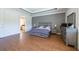Spacious main bedroom features a tray ceiling, wood floors, and ample space for furniture at 10522 Sky Flower Ct, Land O Lakes, FL 34638