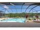 Relaxing screened-in pool with a lake view, surrounded by lush landscaping, perfect for outdoor living at 10522 Sky Flower Ct, Land O Lakes, FL 34638