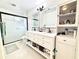 Bathroom featuring a double vanity with framed mirrors, cabinet storage and a glass enclosed shower at 11217 Fiddlewood Dr, Riverview, FL 33579