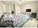 Neutral bedroom with a patterned quilt, chair, TV, and an ensuite bathroom at 11217 Fiddlewood Dr, Riverview, FL 33579