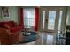Comfortable seating area with red sofa, patterned armchair, and a decorative rug at 11217 Fiddlewood Dr, Riverview, FL 33579