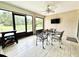 Enclosed sunroom featuring a ceiling fan, tile floor and furniture for relaxation and entertainment at 11217 Fiddlewood Dr, Riverview, FL 33579
