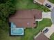Aerial view of a home showcasing its backyard pool, screened lanai, and well-maintained landscaping at 11368 Copley Ct, Spring Hill, FL 34609