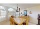 Bright dining room featuring a large window, decorative lighting, and classic wooden furniture at 11368 Copley Ct, Spring Hill, FL 34609