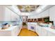 Well-lit kitchen featuring white cabinets, laminate countertops, and view to a breakfast area at 11368 Copley Ct, Spring Hill, FL 34609