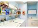Functional laundry room featuring side-by-side washer and dryer, ample shelving, and a utility sink at 11368 Copley Ct, Spring Hill, FL 34609