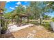 Backyard featuring a covered patio, lake views and mature trees, creating a serene outdoor space at 13643 Tramore Dr, Odessa, FL 33556