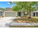 Inviting single-story home with a two-car garage, a covered entrance and established trees in the front yard at 13643 Tramore Dr, Odessa, FL 33556
