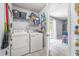 Convenient laundry room featuring a washer, dryer, and shelving for storage. Opens to the kitchen and backyard at 13643 Tramore Dr, Odessa, FL 33556