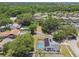 Aerial view featuring a screened pool and solar panels in a home located in a wooded suburban neighborhood at 13835 Pathfinder Dr, Tampa, FL 33625