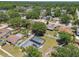 An aerial shot captures a home with a screened pool, complemented by solar panels and mature trees at 13835 Pathfinder Dr, Tampa, FL 33625