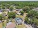 An aerial view showcases a home, complete with a screened pool and solar panels in a leafy neighborhood at 13835 Pathfinder Dr, Tampa, FL 33625