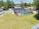 Spacious backyard features a screened pool, solar panels, and is enclosed by a white privacy fence at 13835 Pathfinder Dr, Tampa, FL 33625